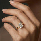 Woman wearing emerald-cut diamond hidden halo engagement ring in 14K yellow gold - lifestyle photo