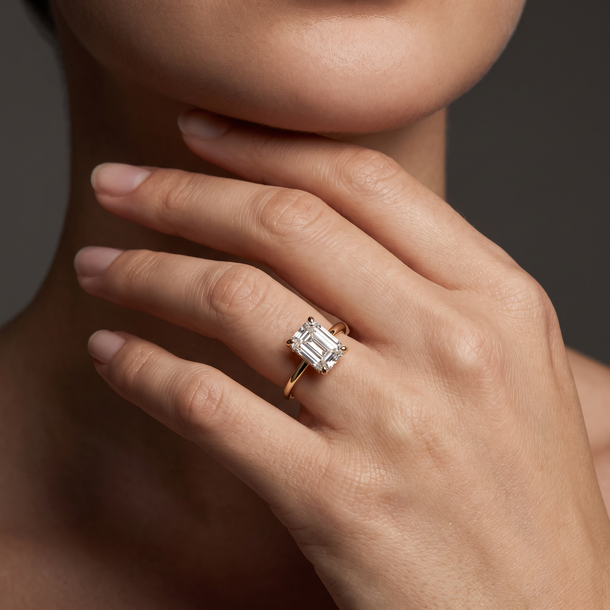Emerald cut hidden halo engagement ring in 14K gold worn on hand, pave visible beneath the crown