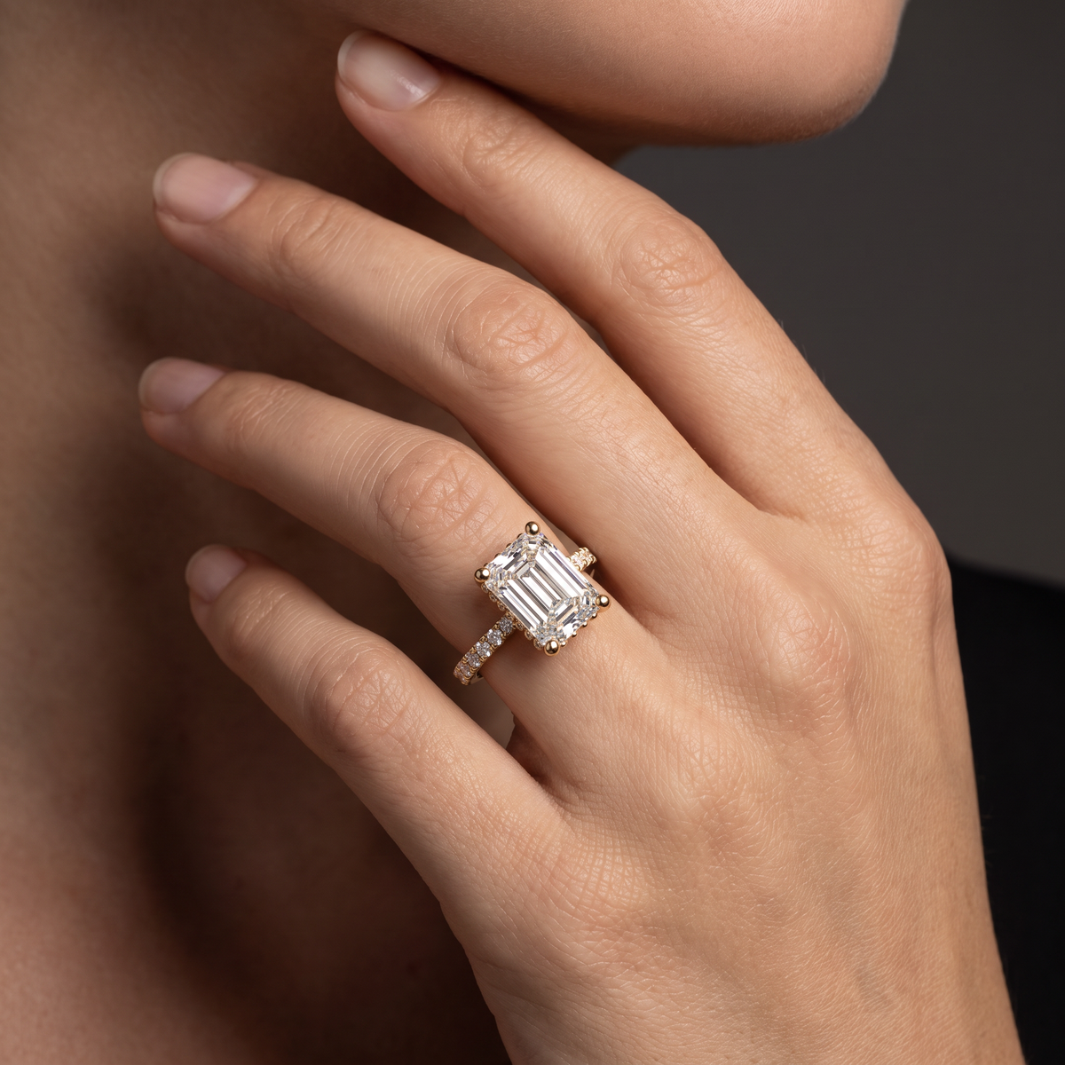 1.5ct Emerald Cut Lab-Grown Diamond engagement ring worn on the hand, showing the 14K gold pavé band on the finger