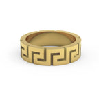 Close-up of solid gold Greek key ring with meander design on white surface