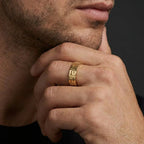 Man wearing solid 14K yellow gold Greek key meander wedding band on ring finger – lifestyle close-up showing full pattern detail