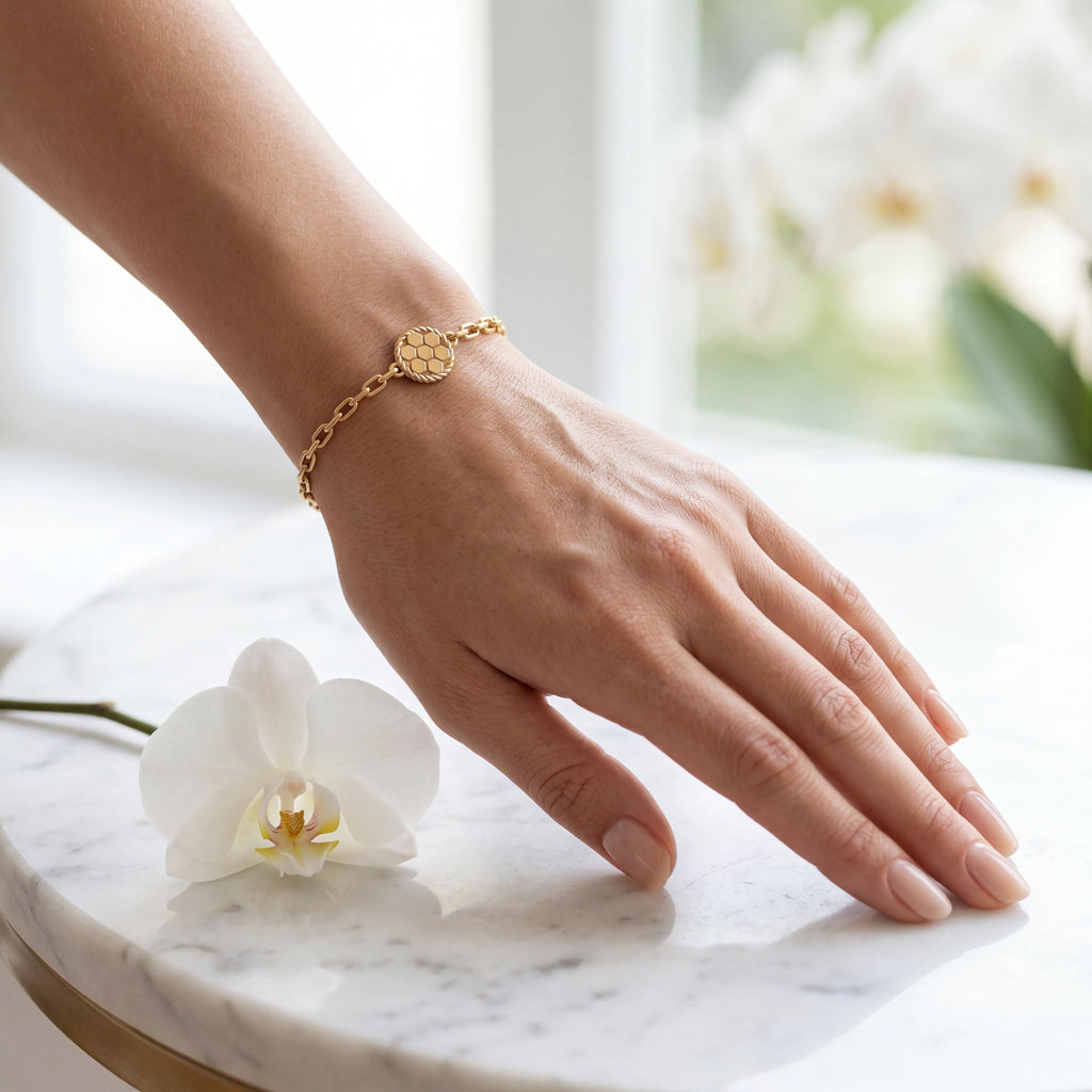 Woman wearing solid 14K yellow gold honeycomb chain bracelet on the wrist — Black Pearl of Queens