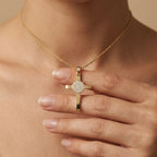 Woman holding ICXC NIKA cross pendant in 14K gold - ancient Greek Orthodox Christian jewelry handcrafted in NYC