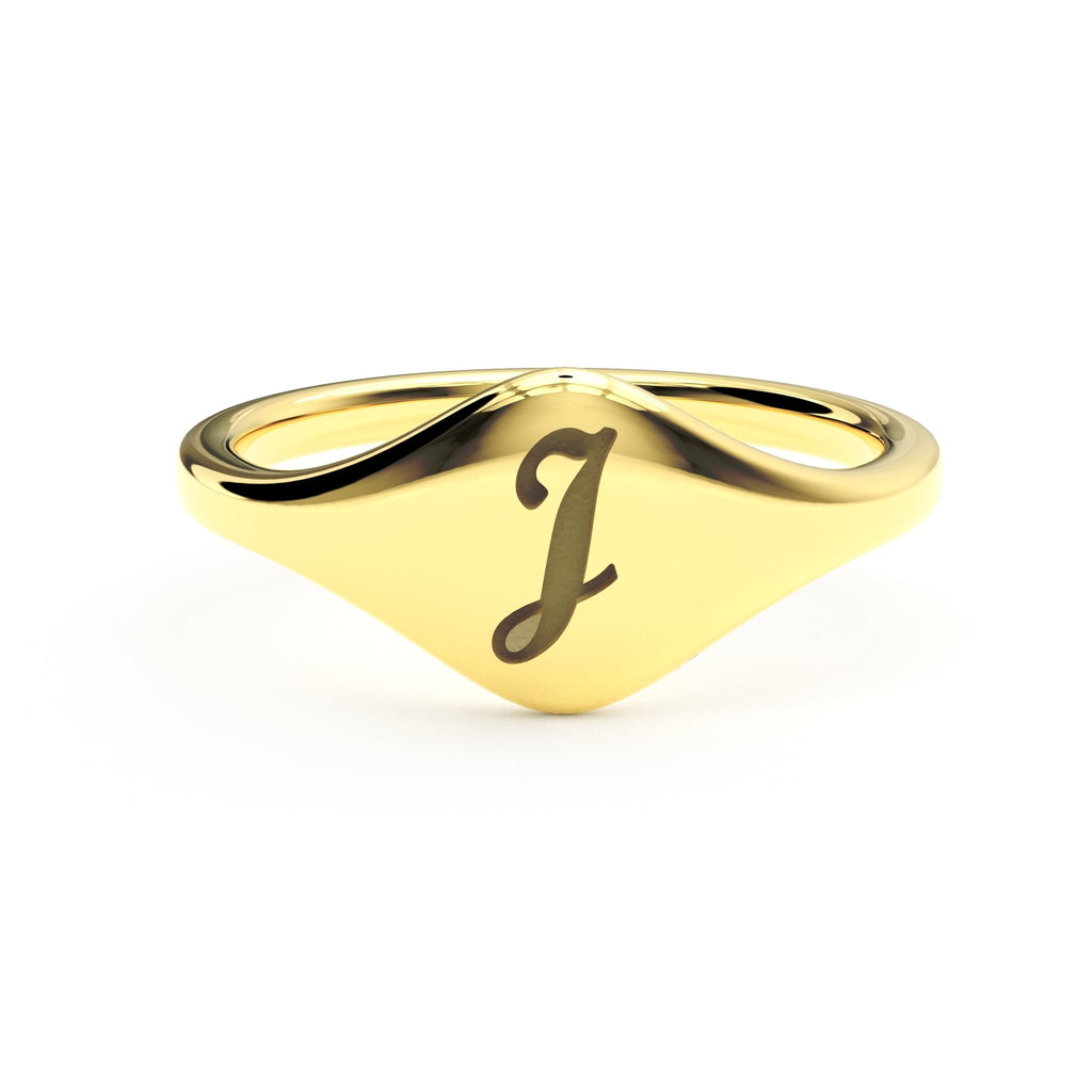 J initial cursive signet ring in polished 14K gold on a soft beige background.
