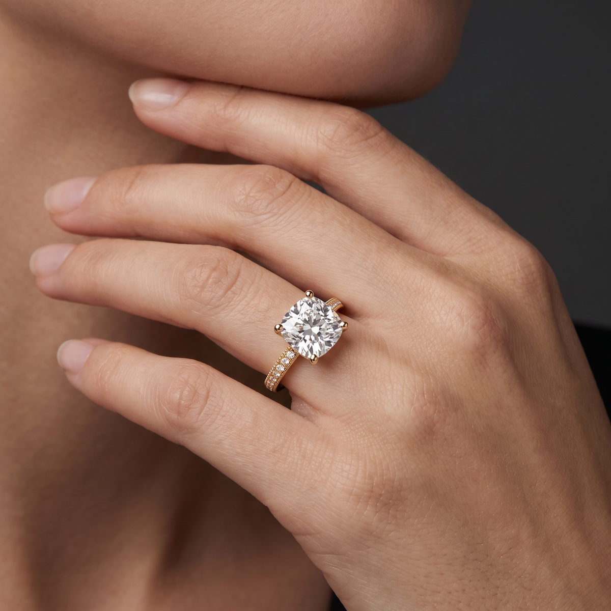 Hand wearing a cushion cut Lab-Grown Diamond milgrain pavé engagement ring in 14K yellow gold