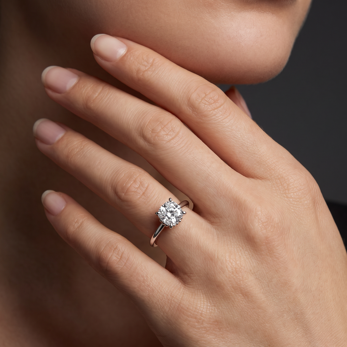 Hand wearing a cushion cut Lab-Grown Diamond solitaire engagement ring in solid 14K gold