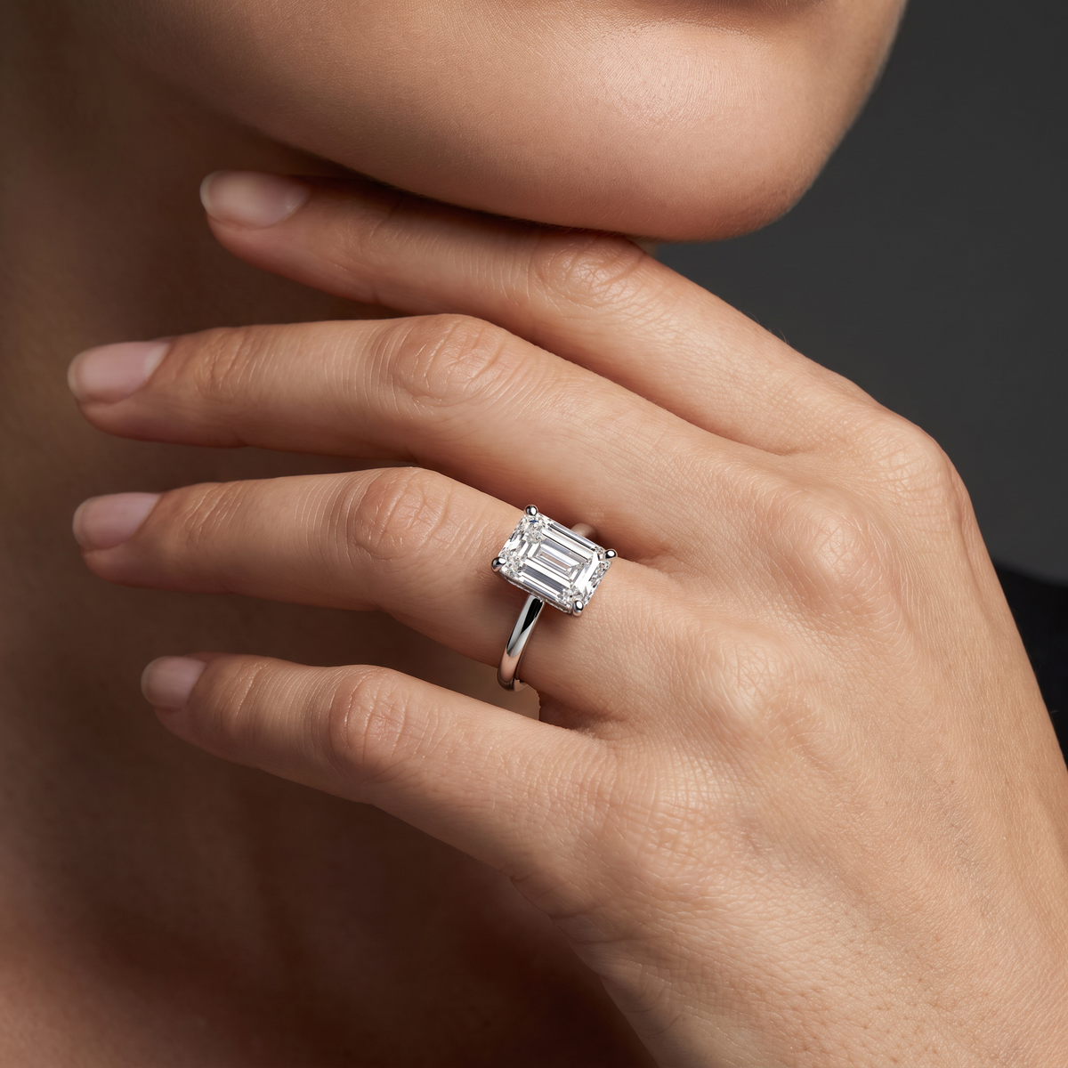 Hand wearing an emerald cut Lab-Grown Diamond solitaire engagement ring in 14K white gold