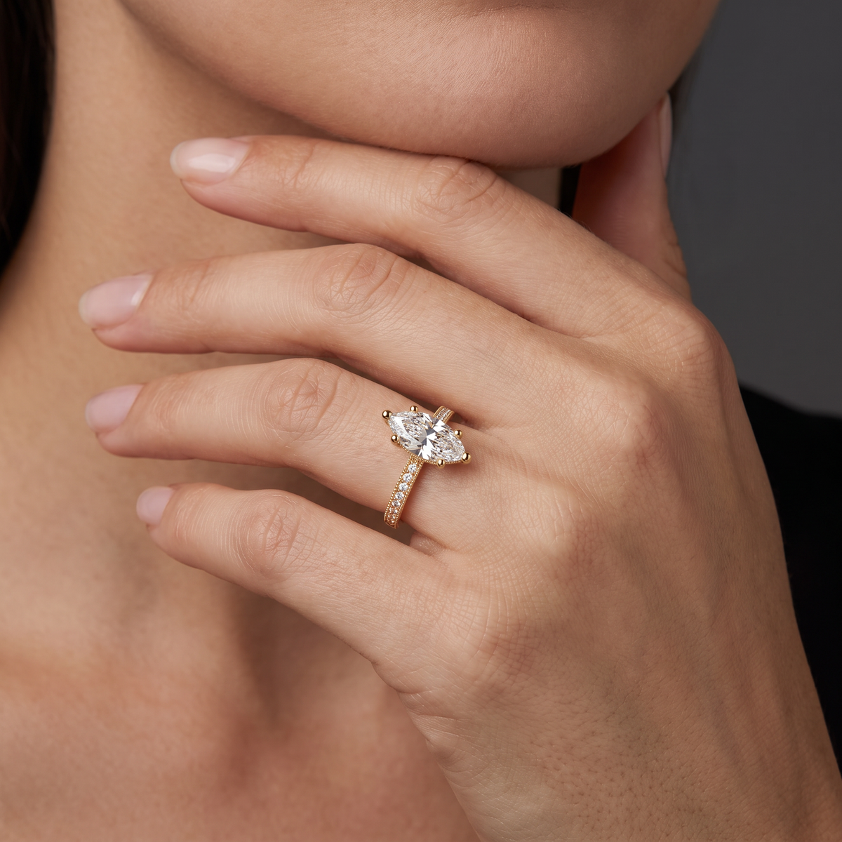 Hand wearing a marquise Lab-Grown Diamond milgrain pavé engagement ring in 14K yellow gold