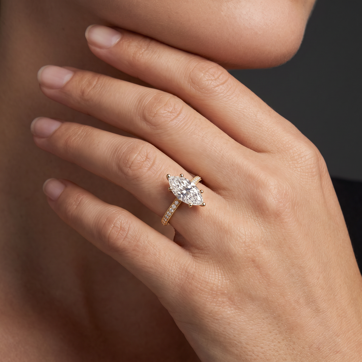 Hand wearing a marquise Lab-Grown Diamond pavé engagement ring in solid 14K gold