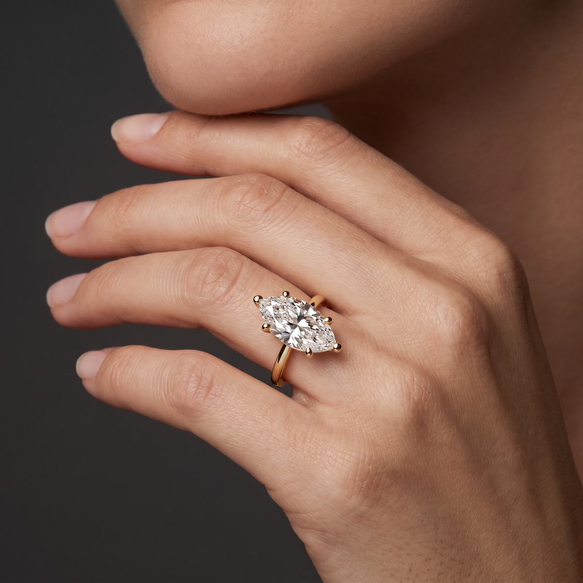 Hand wearing a marquise Lab-Grown Diamond solitaire engagement ring in 14K white gold