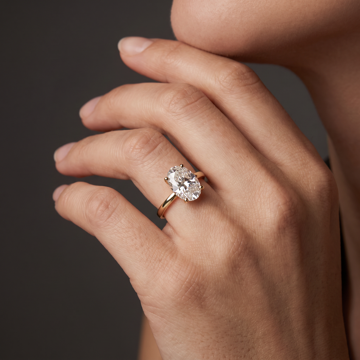 Hand wearing an oval Lab-Grown Diamond solitaire engagement ring in 14K white gold