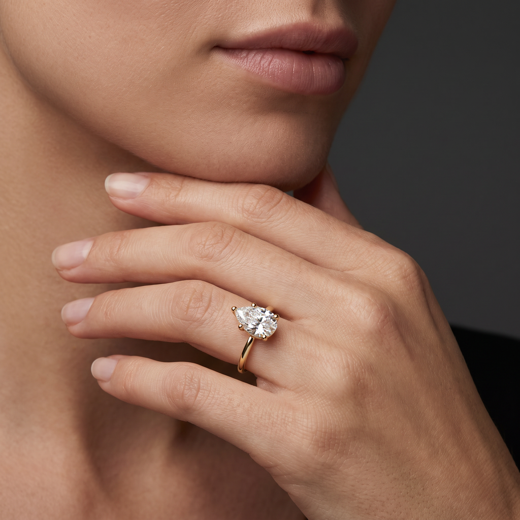 Hand wearing a pear-shaped Lab-Grown Diamond solitaire engagement ring in 14K white gold