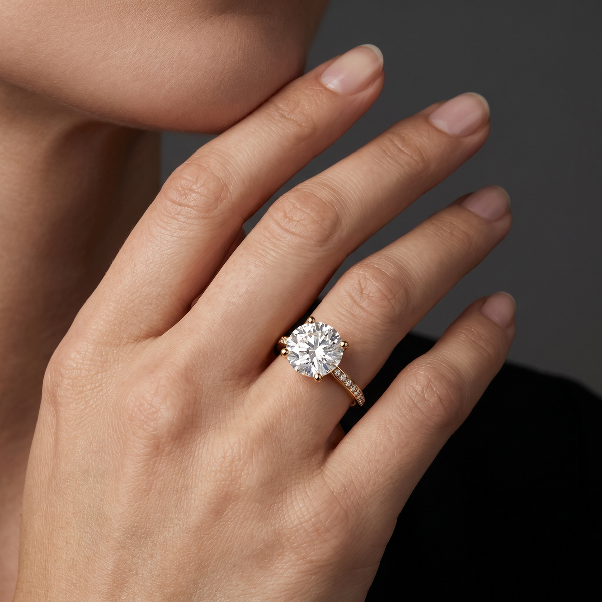 Hand wearing a round Lab-Grown Diamond pavé engagement ring in 14K yellow gold