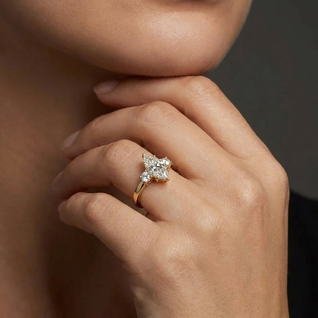 Woman wearing the 1ct marquise three-stone engagement ring in 14K yellow gold, showing how the marquise elongates the finger