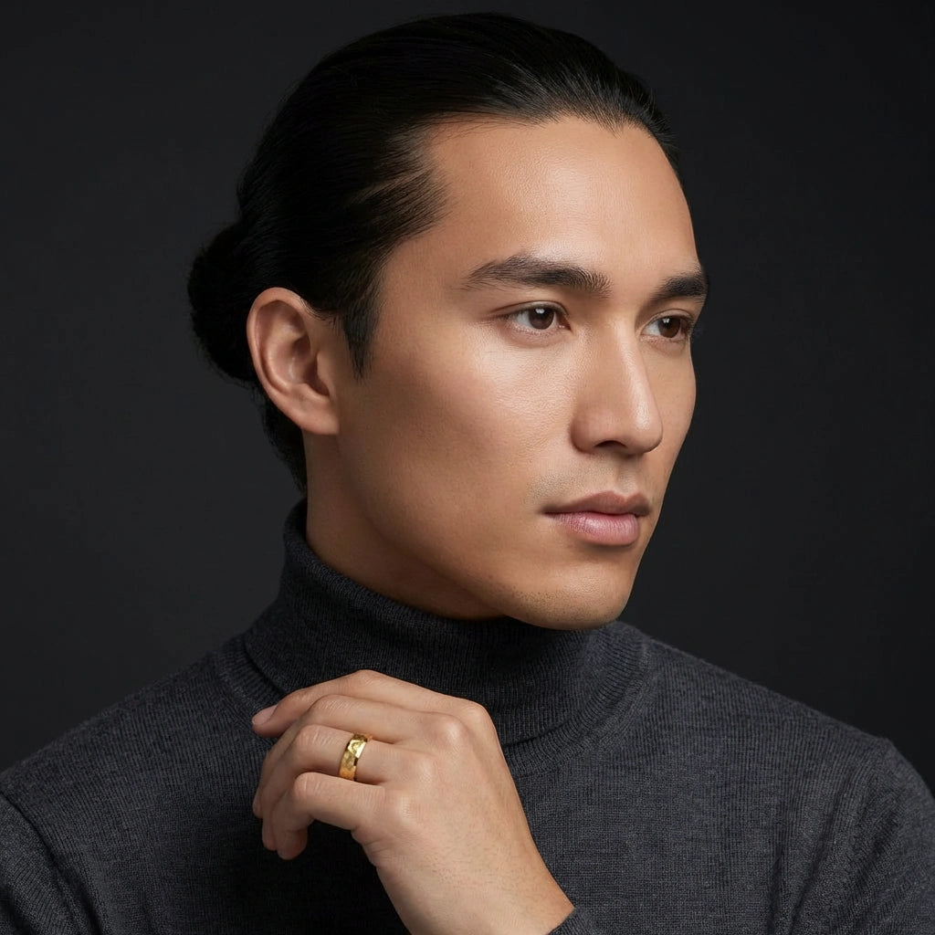 Portrait of a man wearing a 14K yellow gold wedding band, luxury men’s wedding ring styled with dark background and studio lighting.