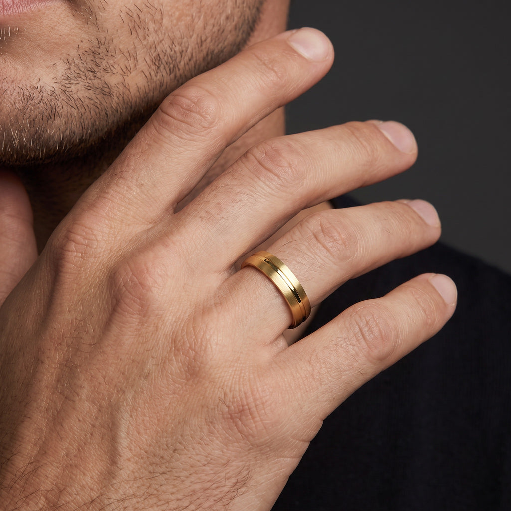Man wearing a 5mm brushed gold wedding band with a polished groove, 14K yellow gold on the finger