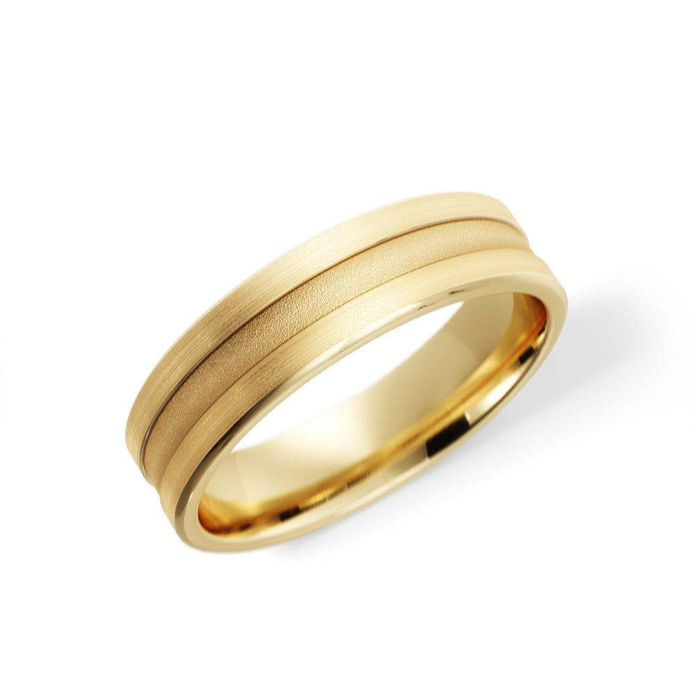 Angled view of men's grooved wedding band in 14K yellow gold, fine grooves dividing the sandblasted center from the brushed rails, comfort-fit interior