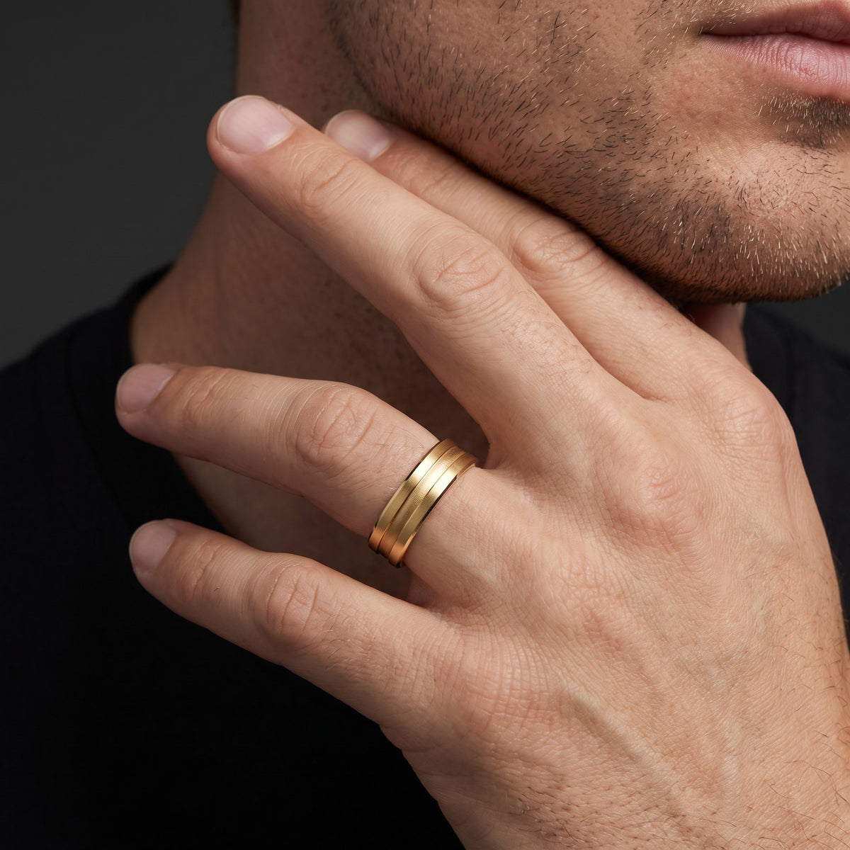 Man wearing a 6mm grooved sandblasted wedding band in 14K yellow gold, showing the matte two-finish design on the finger