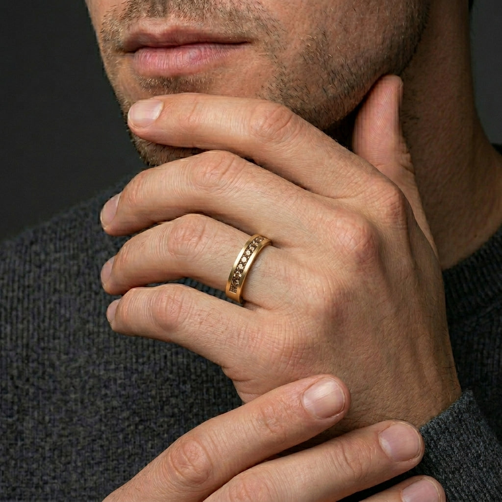 Man wearing the Men's Natural Cognac Diamond Wedding Band in 14K yellow gold, hand to chin