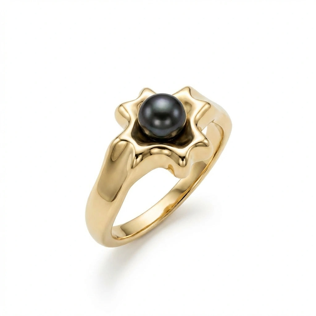 Noir Astra Black Pearl Ring in solid 14K yellow gold, angled view showing sculptural starburst setting and black pearl