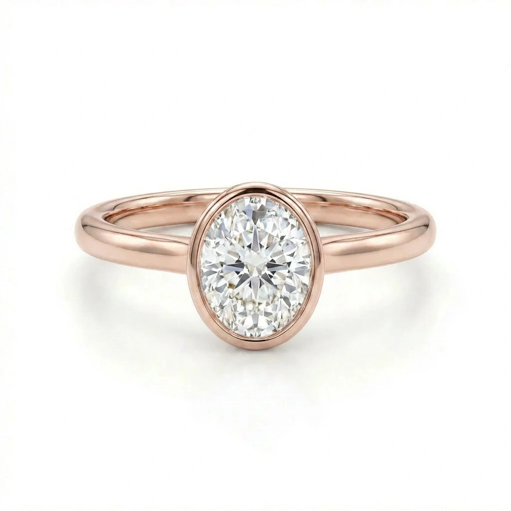 Solid 14K rose gold oval cut diamond ring with bezel set center stone and sleek band