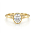 Solid 14K yellow gold oval cut diamond ring with bezel setting and polished slim band