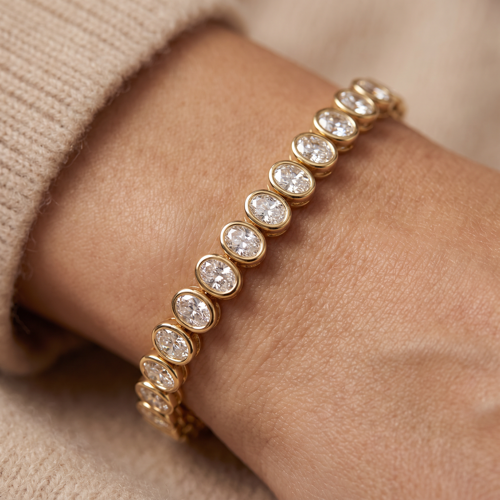 North-south oval bezel tennis bracelet in 14K yellow gold with Lab-Grown Diamonds worn on the wrist