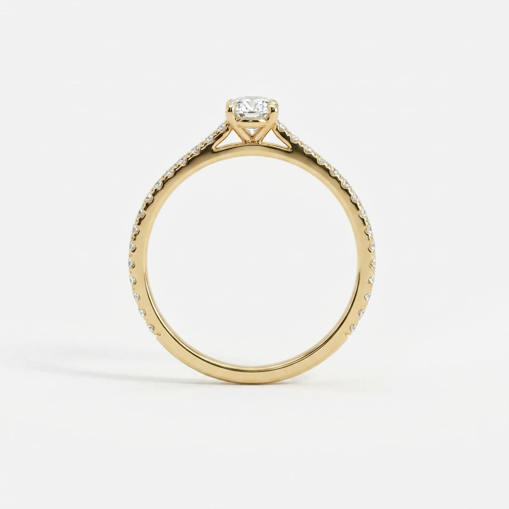 Side profile of oval lab-grown diamond pavé engagement ring in 14K yellow gold with cathedral setting
