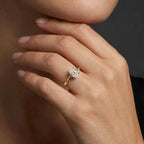 Woman wearing an oval solitaire ultra thin engagement ring in solid 14K yellow gold