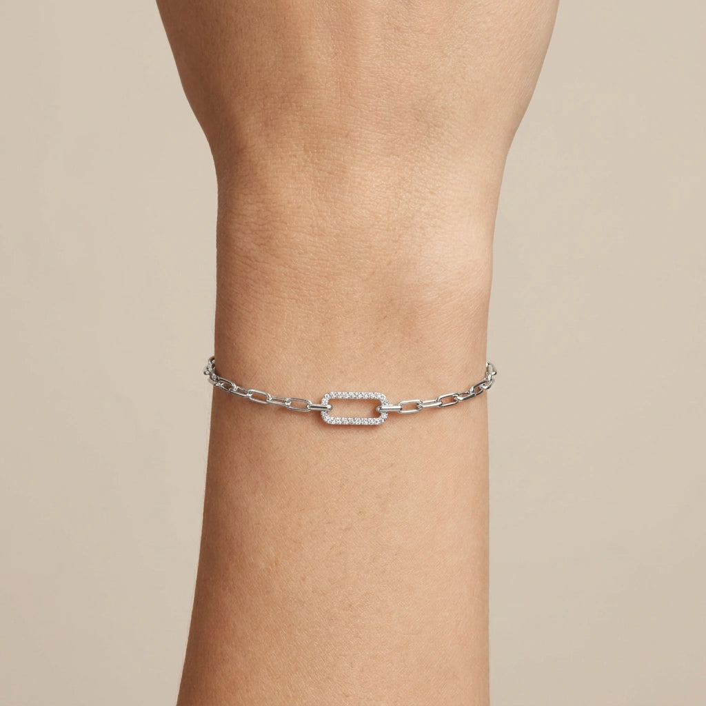 Pavé diamond accent link on white gold paperclip chain bracelet, close-up on wrist — Black Pearl of Queens