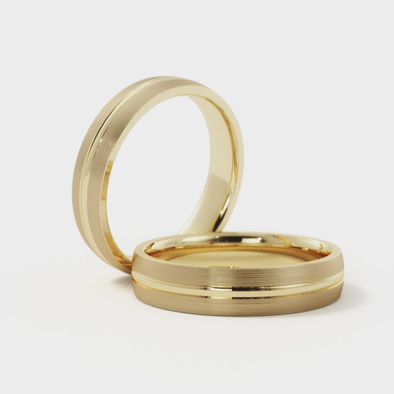 Video of a men's 5mm brushed wedding band in 14K yellow gold, showing the polished groove catching light against the satin finish