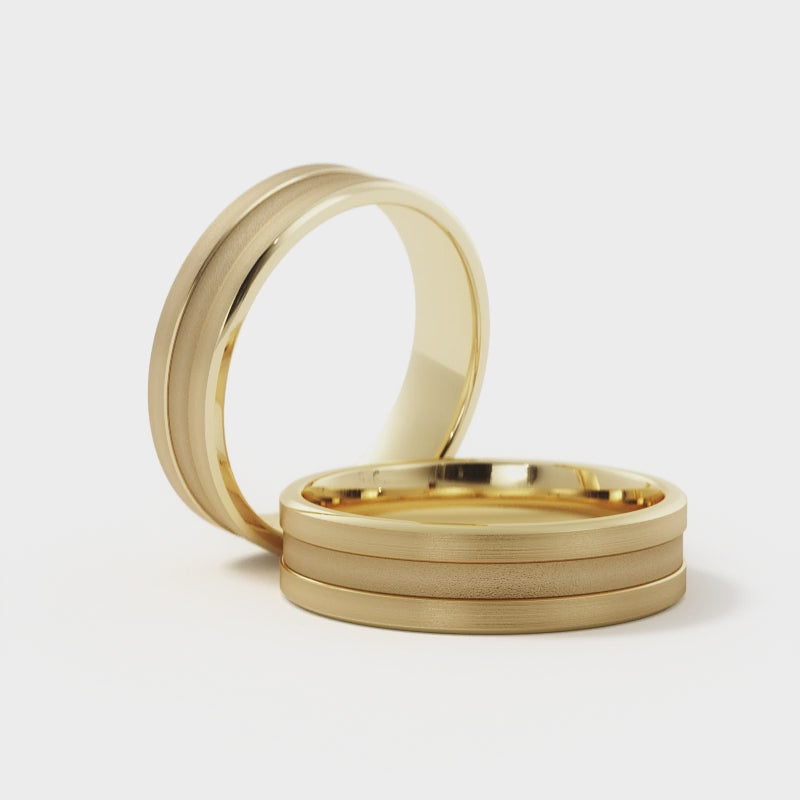 Video of a men's 6mm grooved wedding band in 14K yellow gold rotating to show the sandblasted center, brushed rails and polished bevels