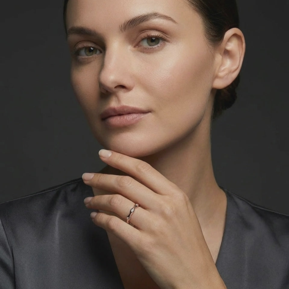 14K rose gold wave diamond ring worn on hand in studio lighting