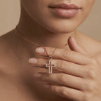Close-up of 14K yellow gold Radiant pavé diamond cross necklace worn on model holding pendant video