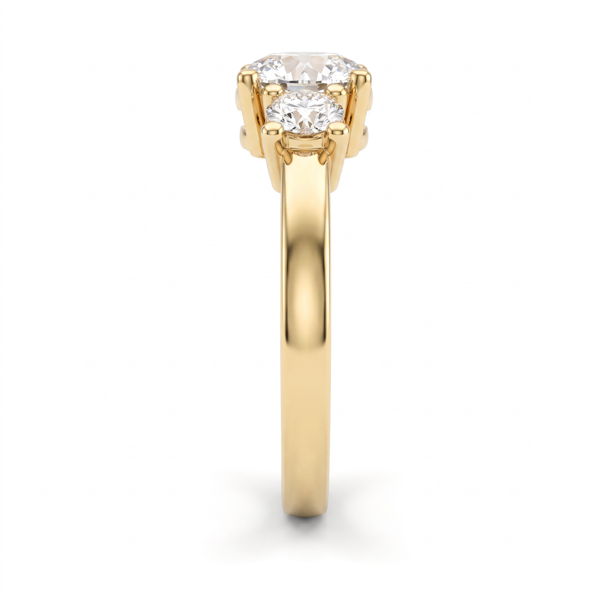 Side profile of round three-stone engagement ring in 14K yellow gold showing setting height and tapered band