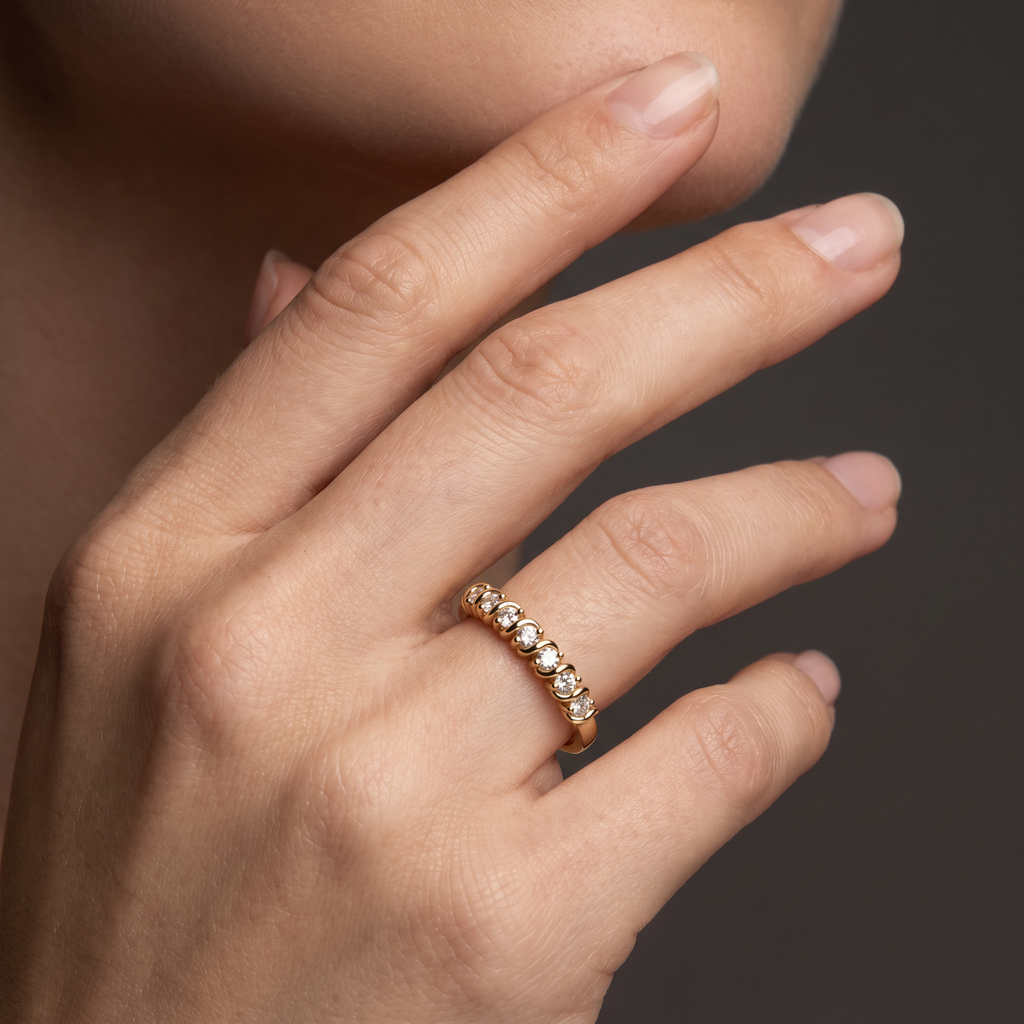 Hand wearing a seven-stone Lab-Grown Diamond wedding band with S-link settings in 14K yellow gold