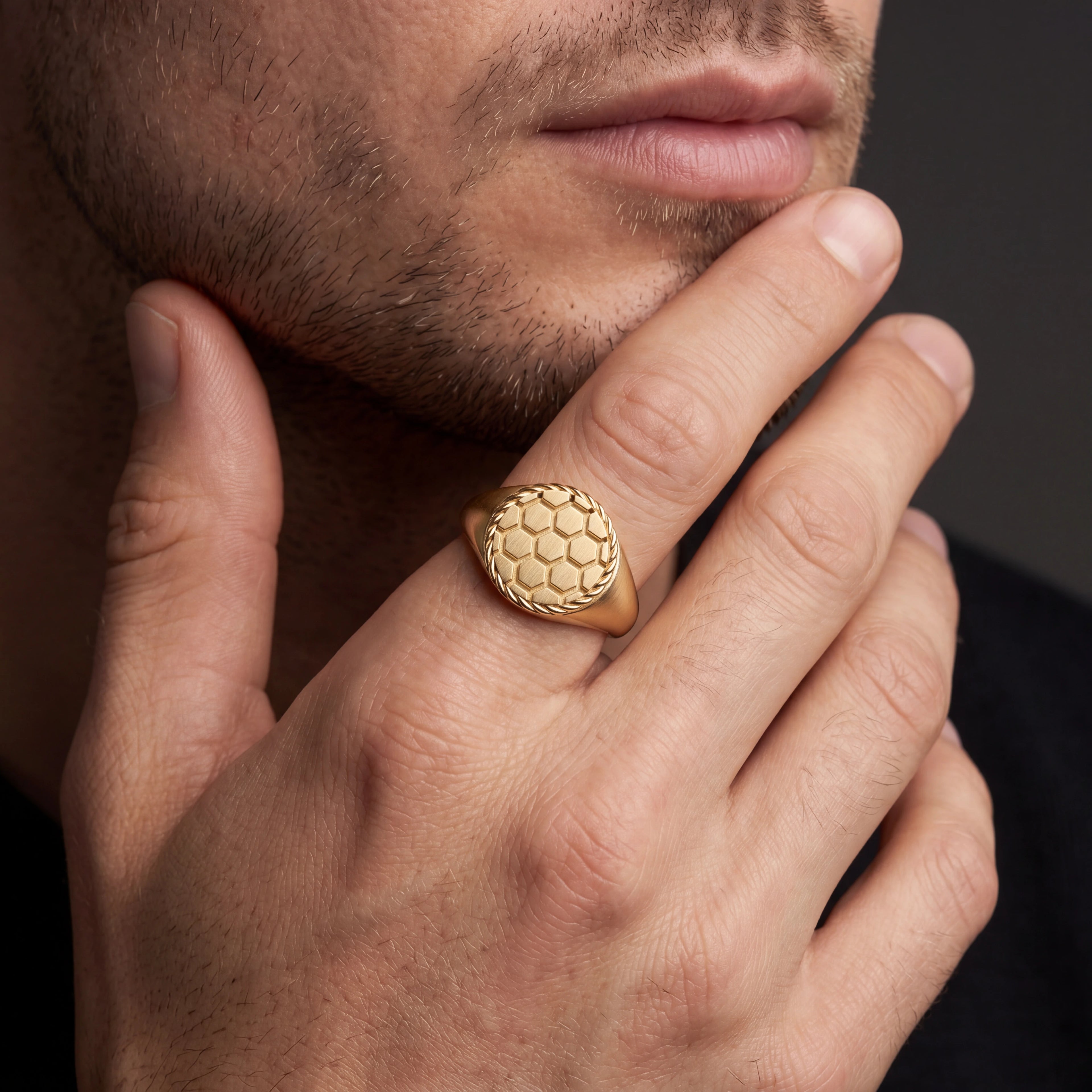 Man wearing solid 14K yellow gold soccer signet ring, close-up on hand — Black Pearl of Queens