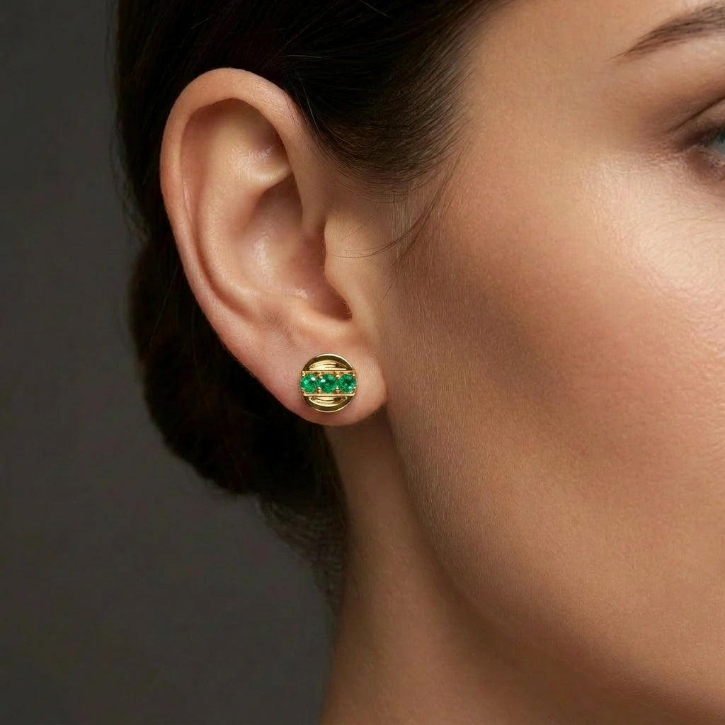 Tauren emerald line stud earrings in solid gold with horizontal row of green gemstones in modern circular design