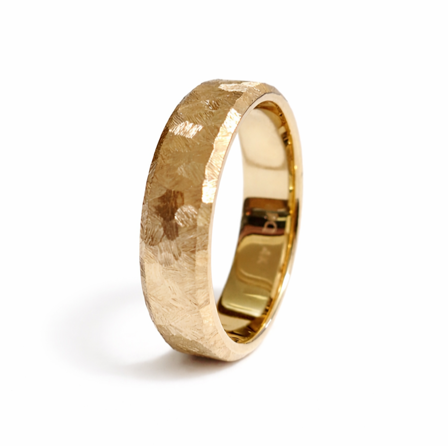 Handcrafted textured 14K yellow gold wedding band with faceted finish