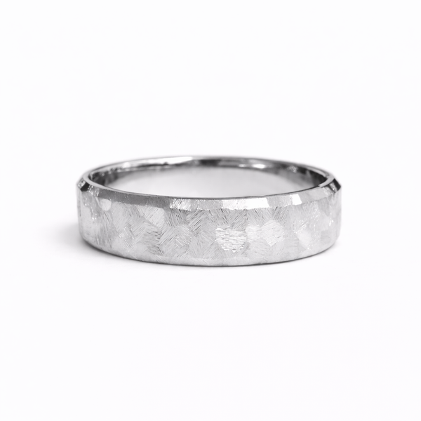 Textured platinum wedding band with hand-worked faceted surface