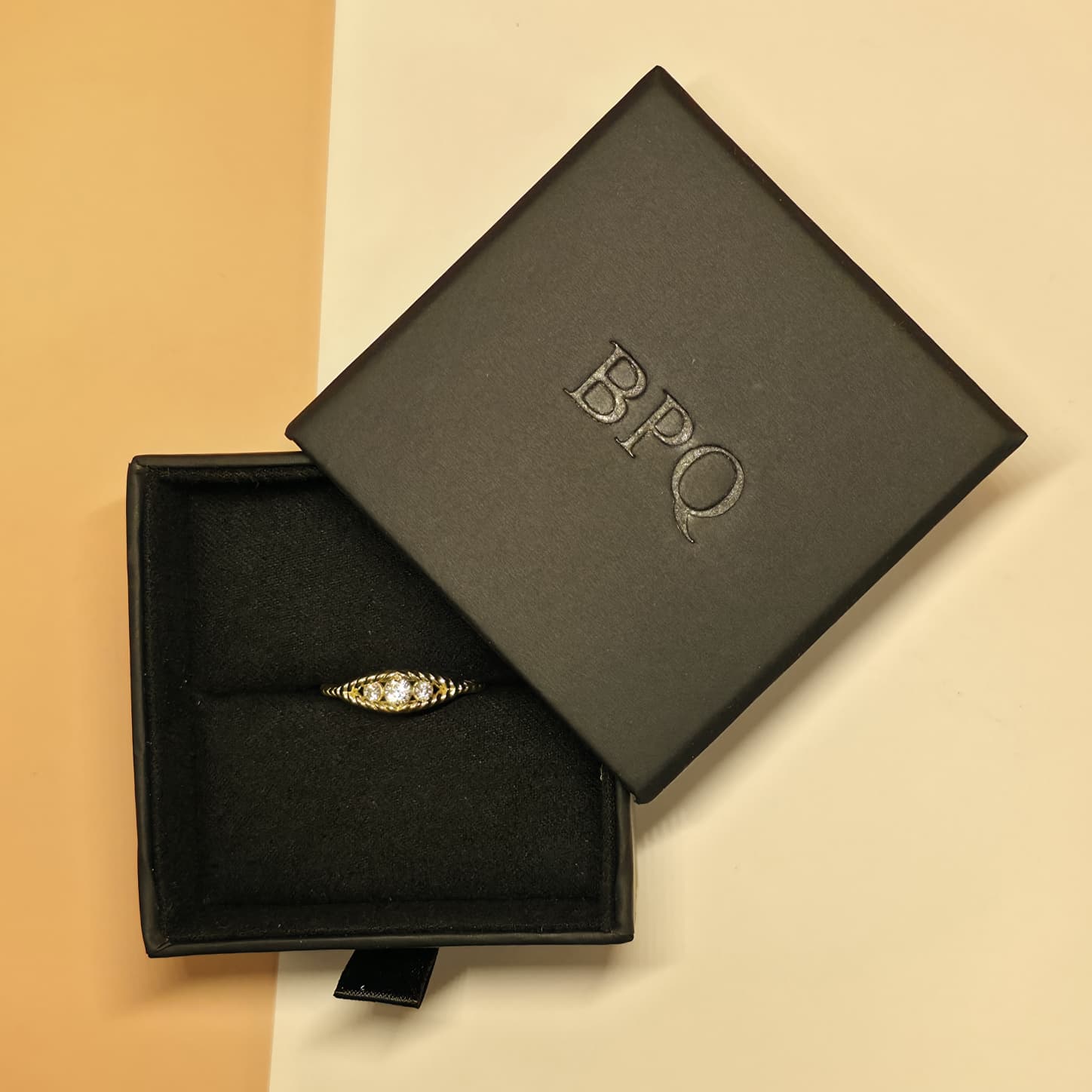 Three stone rope diamond ring presented in Black Pearl of Queens signature jewelry box