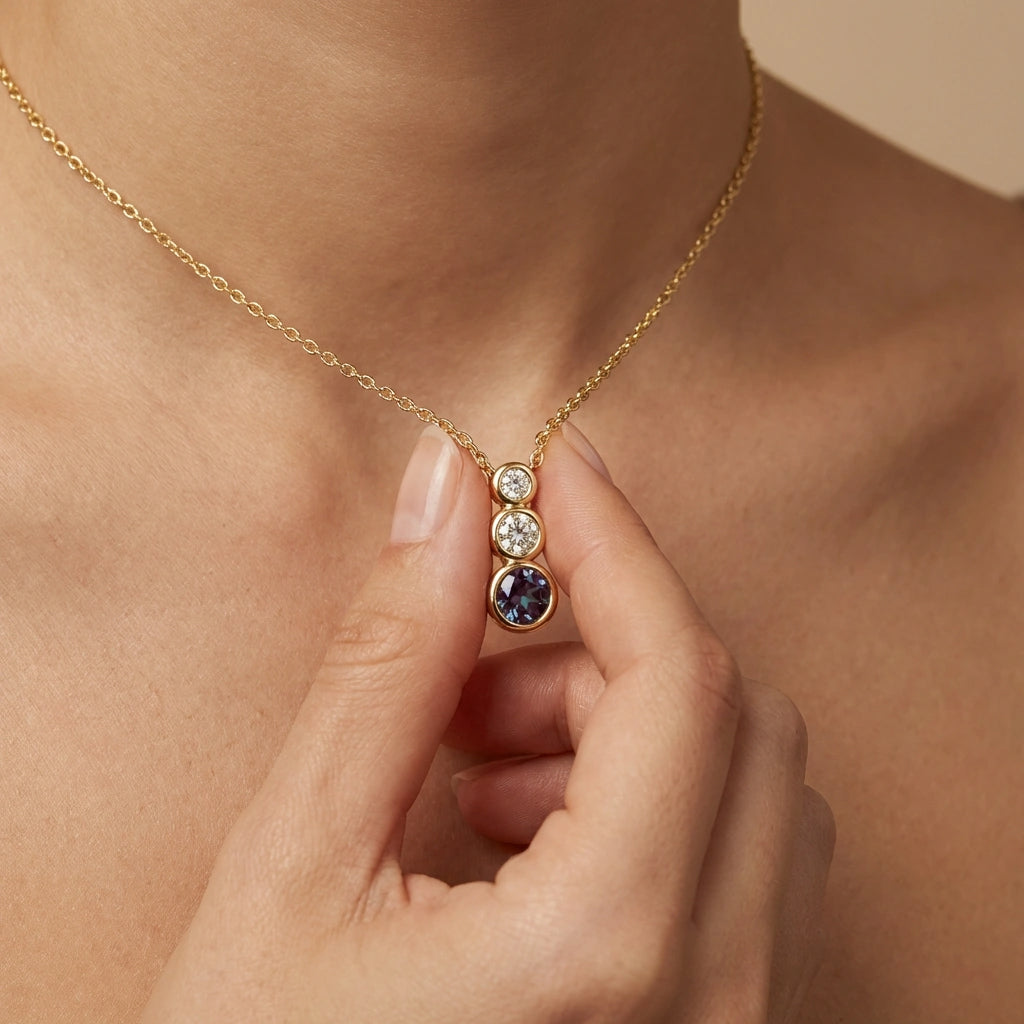 Woman wearing Tria Aura Diamond and Alexandrite Necklace in 14K gold, meaningful birthstone necklace gift for June