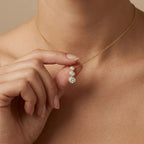 Woman wearing Tria Bezel Diamond Necklace in 14K gold, meaningful three stone diamond necklace gift