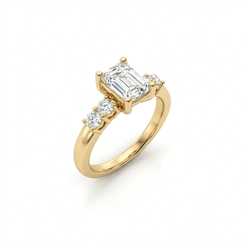 Valen emerald diamond ring in 14k yellow gold, angled view showing emerald cut center stone with round side diamonds