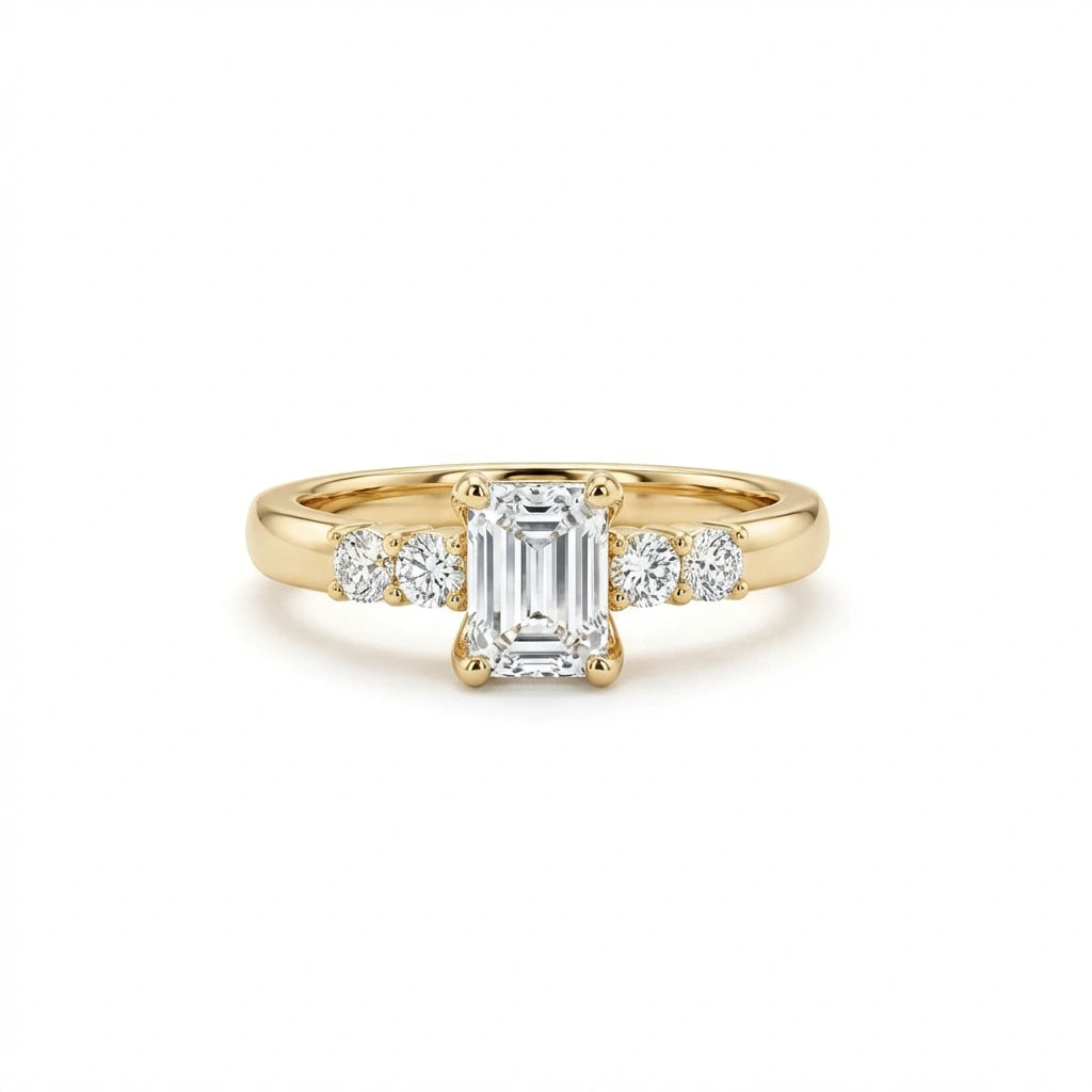 Valen emerald diamond ring in 14k yellow gold, front view with emerald cut center diamond and round side stones