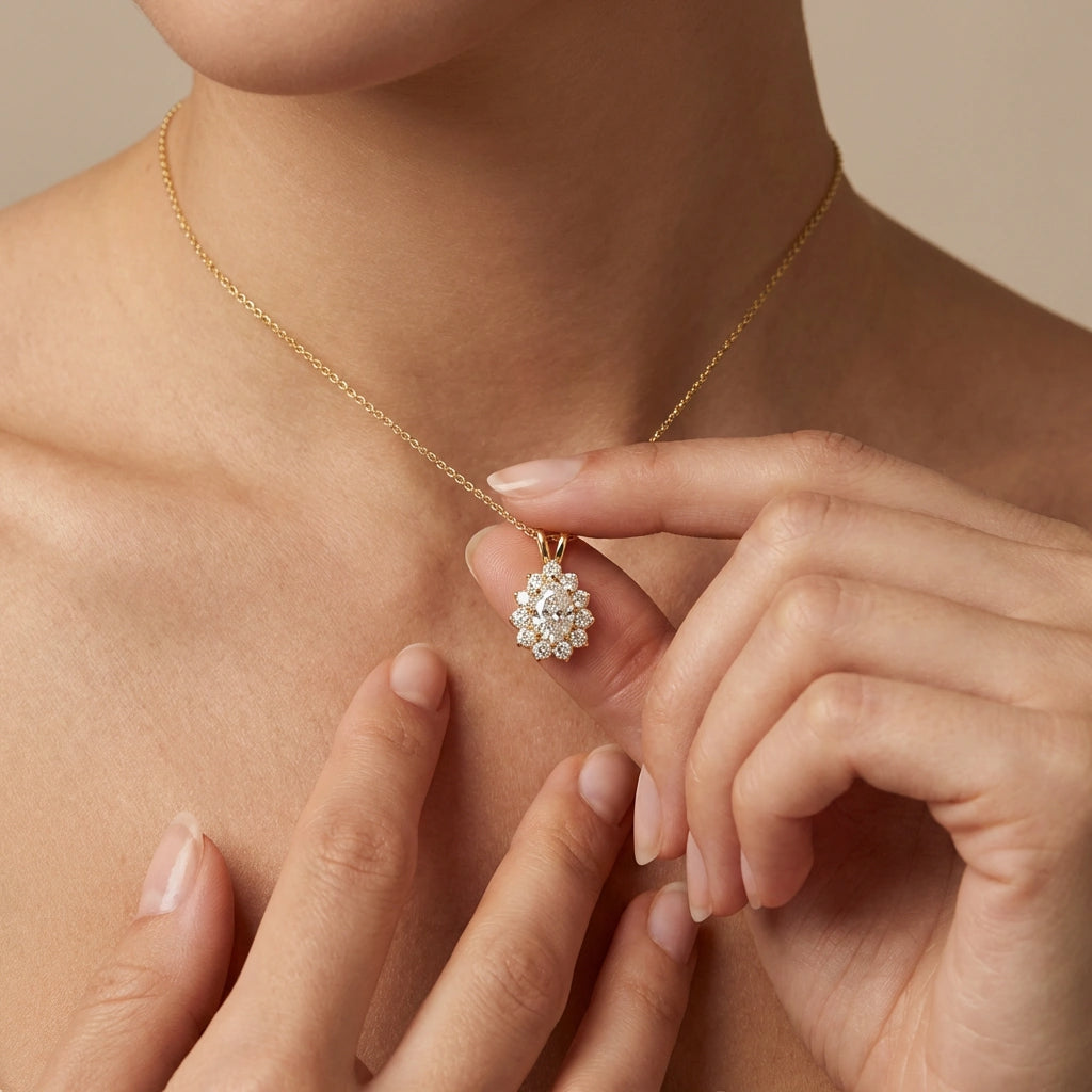 Woman wearing Valeria halo pendant necklace in 14K yellow gold with pear-shaped diamond and halo setting