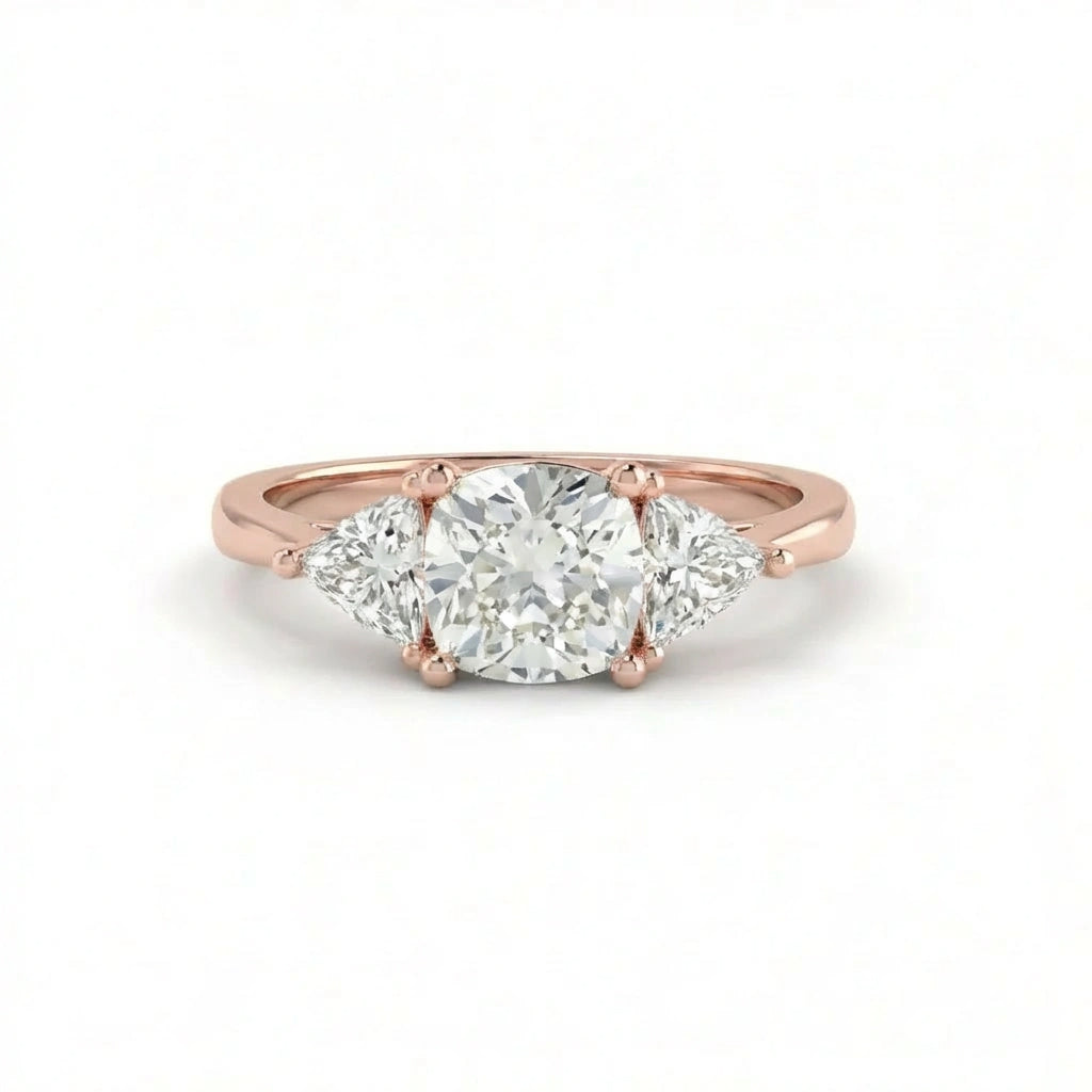 Vela trilogy diamond engagement ring in 14k rose gold with round center diamond and pear side stones, three stone design