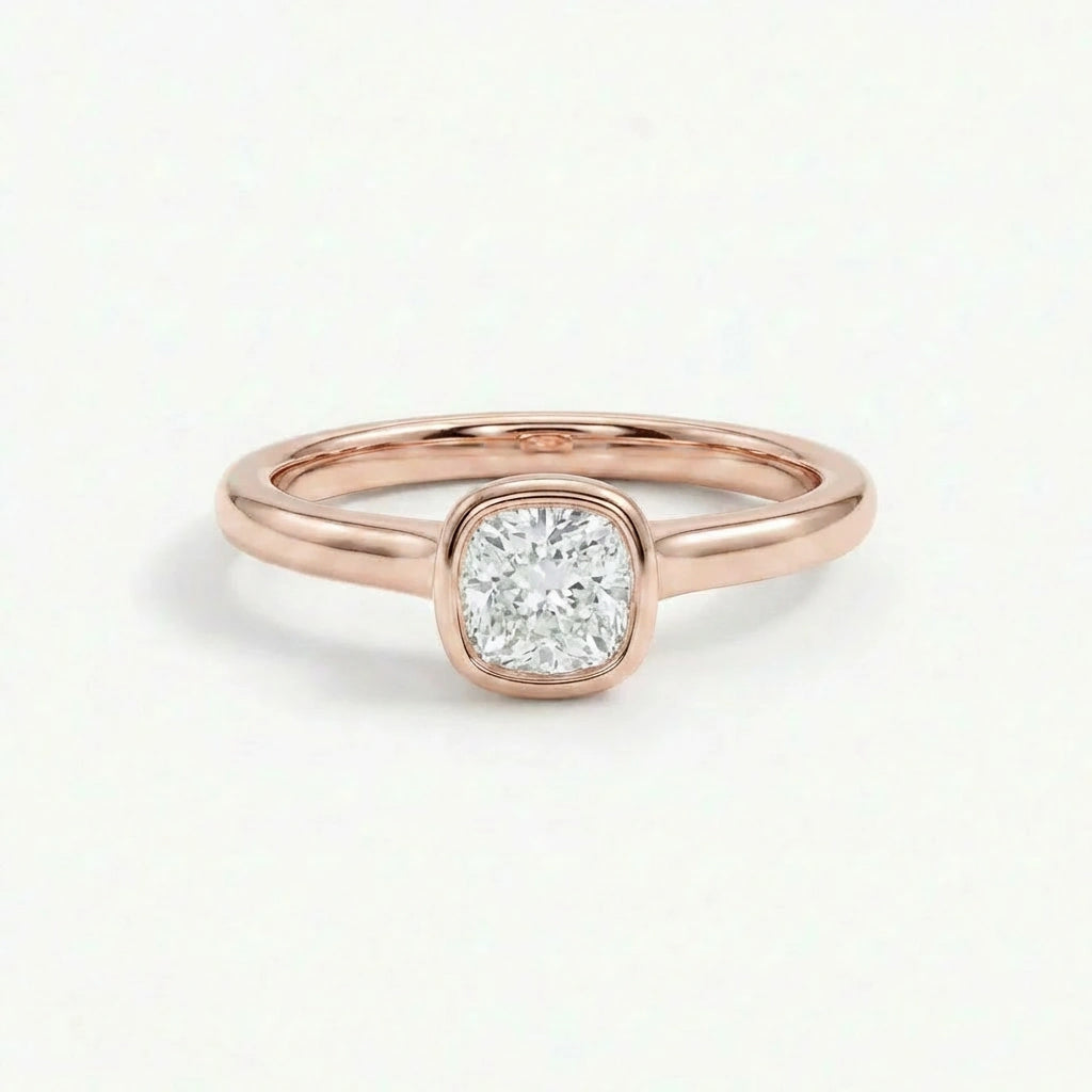 Solid 14K rose gold cushion cut diamond ring with smooth bezel setting and polished band