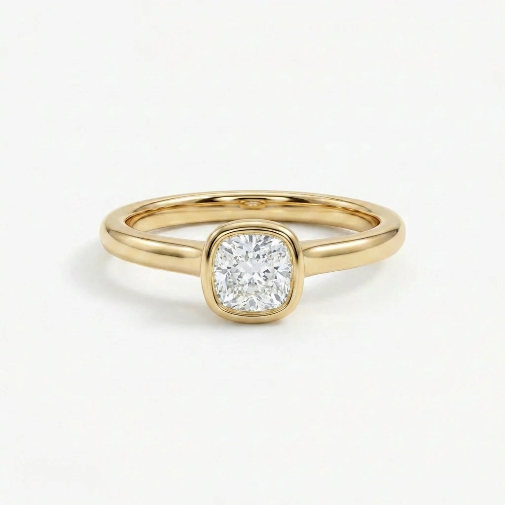 Solid 14K yellow gold cushion cut diamond ring with bezel set center stone and sleek band