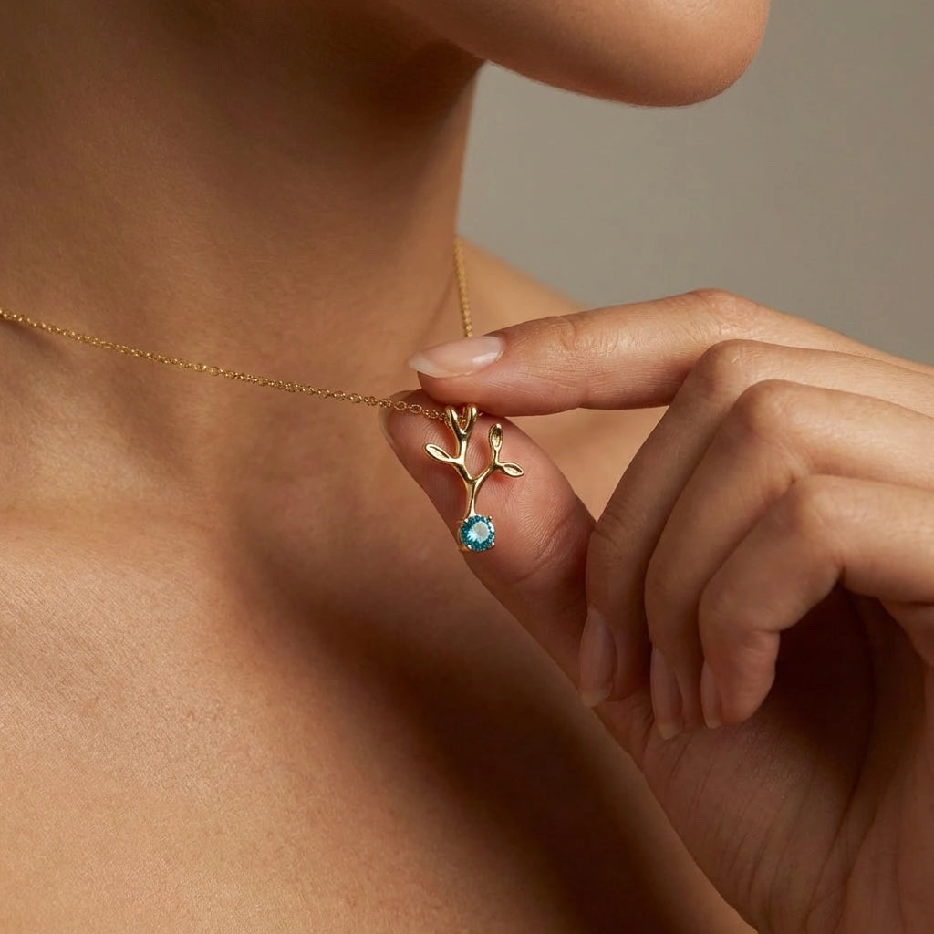 Woman wearing Verdant Branch aquamarine pendant in 14K yellow gold - nature-inspired tree branch necklace